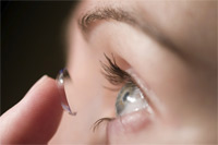 Contact lens being applied to eye.