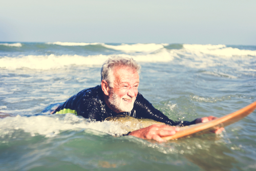 old man surfing ocean 