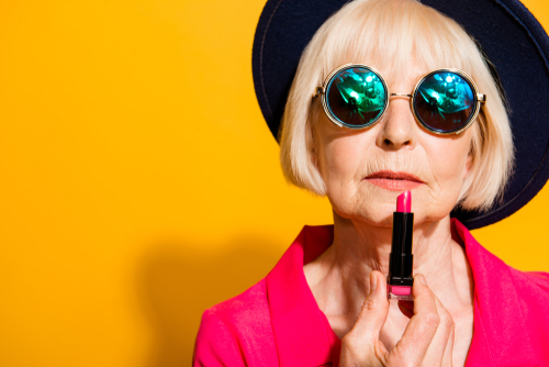 Older woman applying lipstick