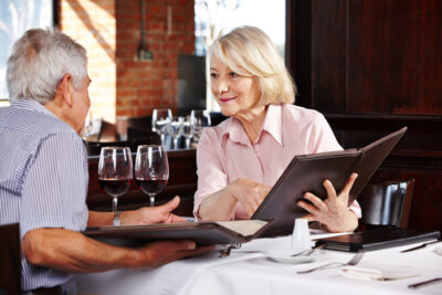 A couple at a restaurant inspecting the menu together